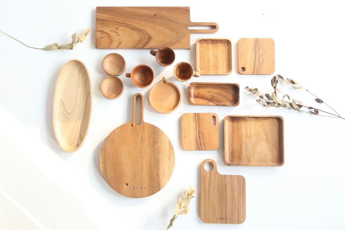 Bộ khay, thớt, thìa bằng gỗ xếp trên nền trắng